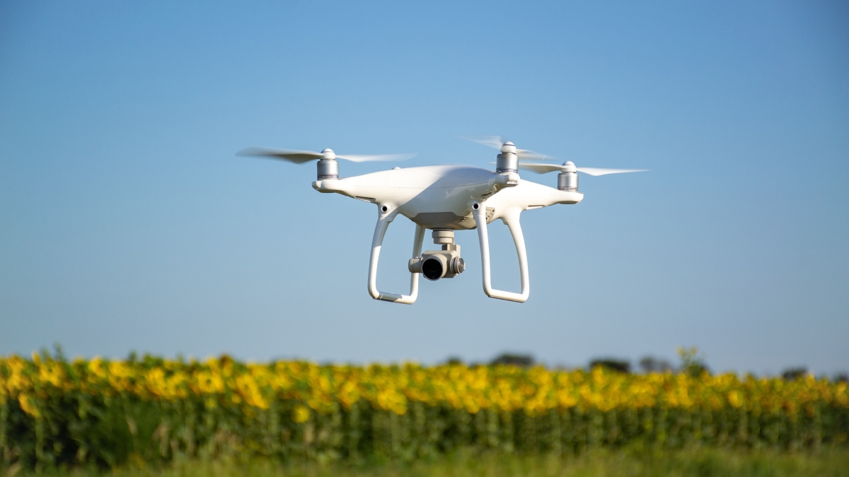 Shot of a drone with camera flying over an open field