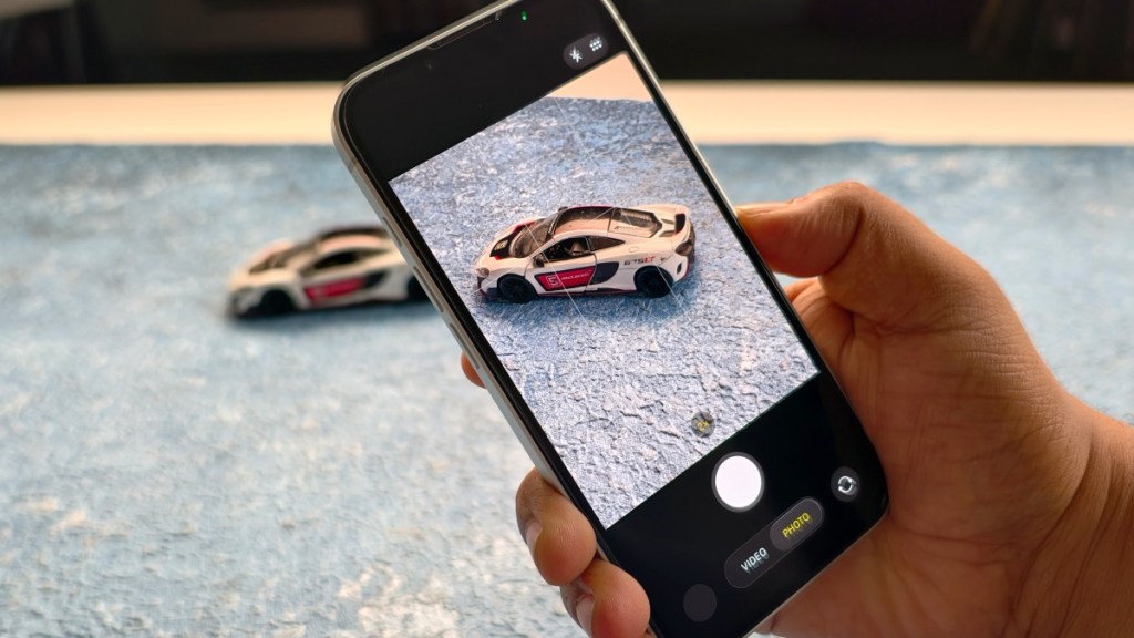 Blue iPhone 13 focusing on a toy car