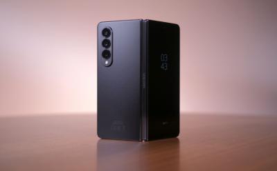 The Samsung Galaxy Z Fold 4 placed on a wooden surface with a brown background