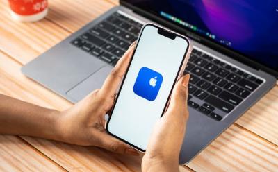 Apple Support app on iPhone with a MacBook in the background
