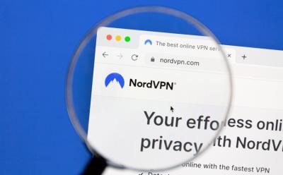 This image depicts the Nord VPN webpage under a magnifying glass