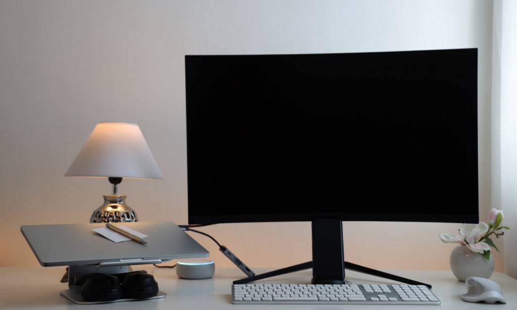 shot of an external monitor connected to a laptop, both placed on a desk