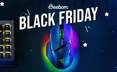 Razer Basilisk V3 Pro with RGB lighting turned on placed on a desk next to a backlit mechanical keyboard with Black Friday text at the top
