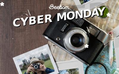 Top view of a camera with photographs lying around and Cyber Monday text at the top