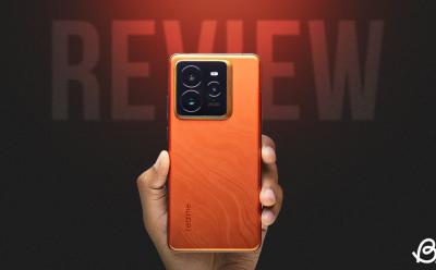 Realme GT back panel design in hand in front of an orangish-black background