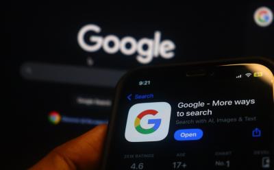 hand holding iPhone with Google Search App Store listing