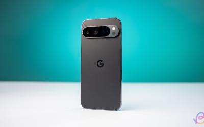 shot of the Google Pixel 9 Pro in black colorway placed upright on a white desk