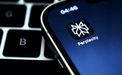 Perplexity AI app on a phone with keyboard behind it