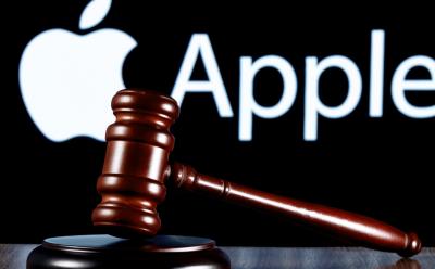 Gavel on table against the background of Apple company logo.