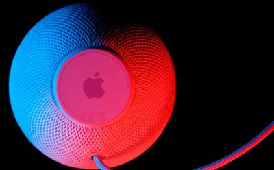 HomePod mini smart speaker with Siri voice assistant by Apple in white, photographed on dark background