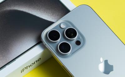 Triple-camera Apple iPhone 15 Pro Max showcased on bright yellow background