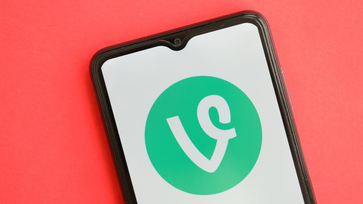 Vine icon on smartphone screen on red table close up.
