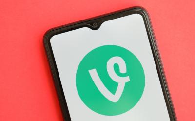 Vine icon on smartphone screen on red table close up.