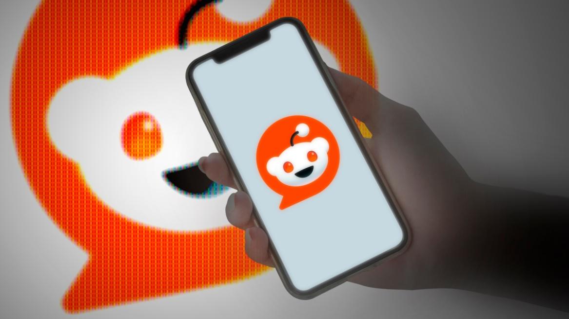 Reddit logo on a phone and in the background