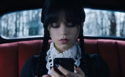Wednesday Addams looking at her phone in Wednesday