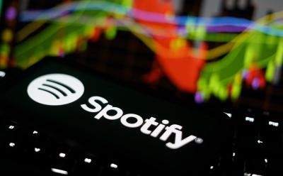 Spotify label on a phone screen sitting on a laptop with backlit keyboard