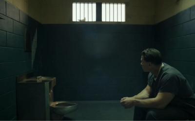 Peacemaker being held in a holding cell