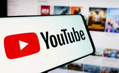 YouTube-logo-on-a-smartphone-in-front-of-a-desktop-screen