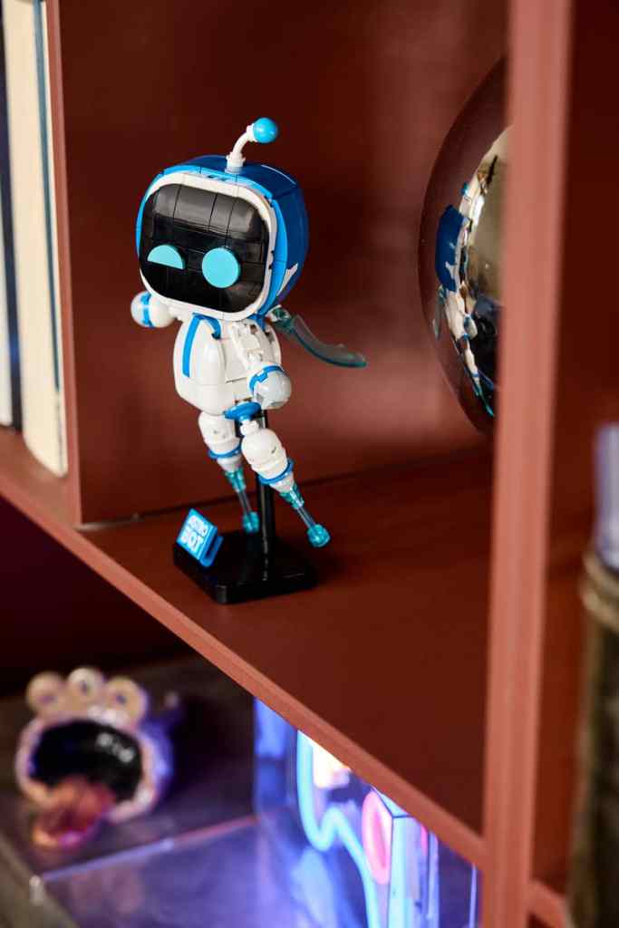 LEGO Astro Bot on a bookshelf.