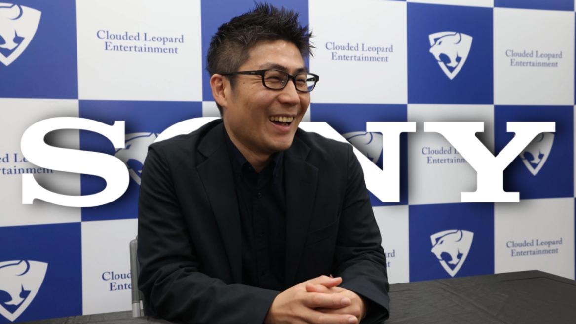 NIS America president Kenzo Saruhashi in an interview with the Sony logo in the background.